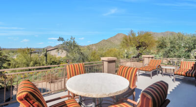A patio with a table and chairs overlooking the mountains in Scottsdale, Arizona at a home in McDowell Mountain Ranch.