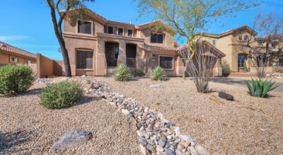A home in Scottsdale, Arizona with rocks and trees in the McDowell Mountain Ranch setting.