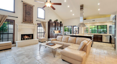 A large living room with a fireplace and ceiling fan located in the Paradise Park Manor neighborhood at McCormick Ranch.