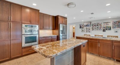Modern kitchen interior with stainless steel appliances, granite countertops, and wooden cabinetry at 6309 E Friess Dr, Scottsdale.